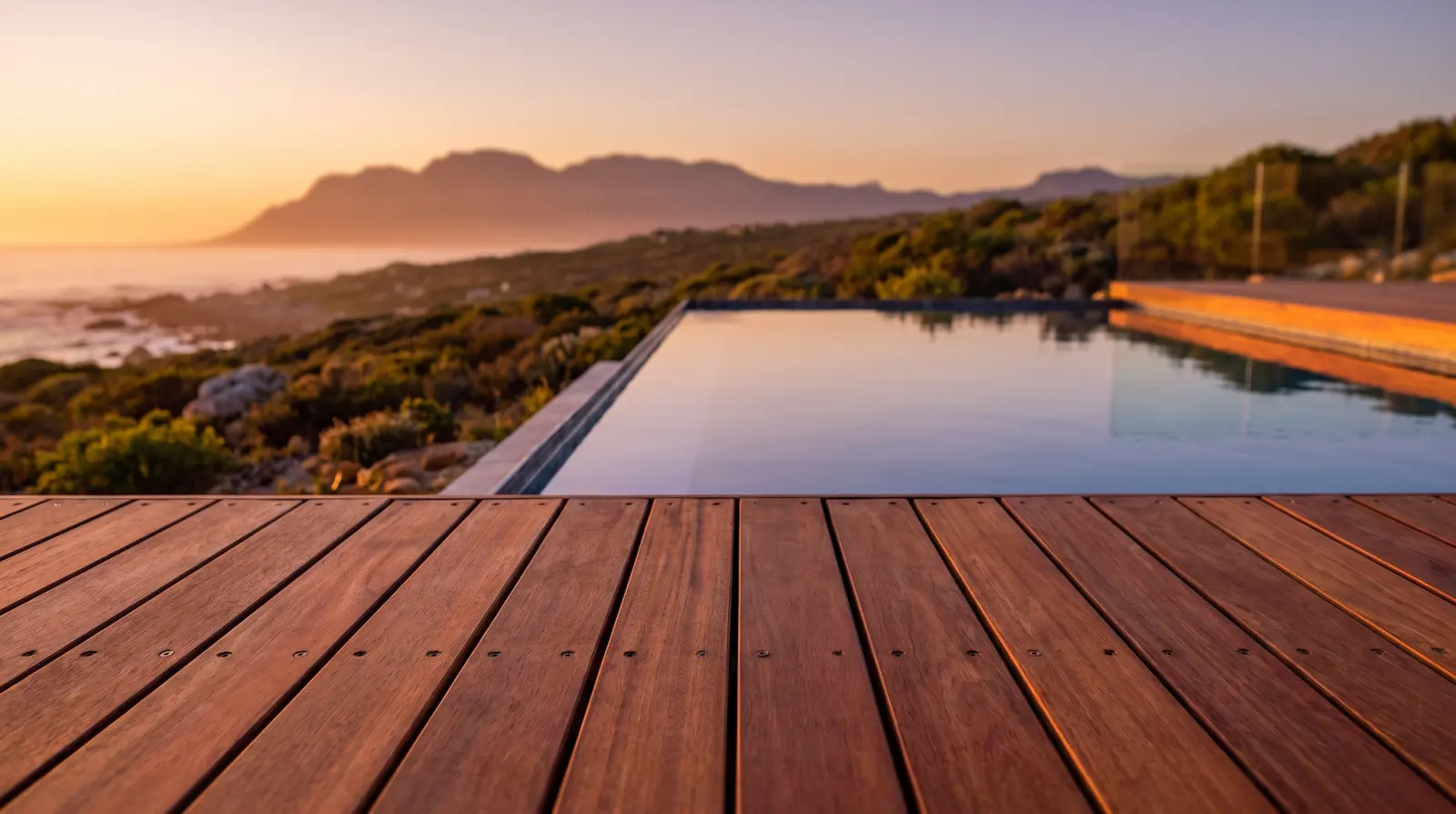 Hardwood decking boards laid beside a pool at sunset
